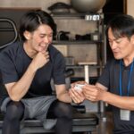 フィットネスアプリを見ながらInstagram集客について話すパーソナルトレーナー